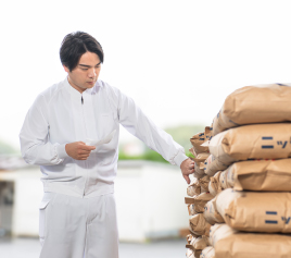 写真：縦に並べられた茶色い紙袋を数えている男性職員