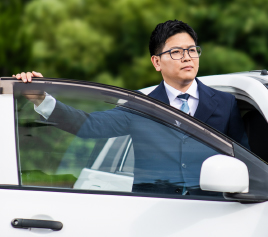 写真：車から降りるスーツを着た男性職員