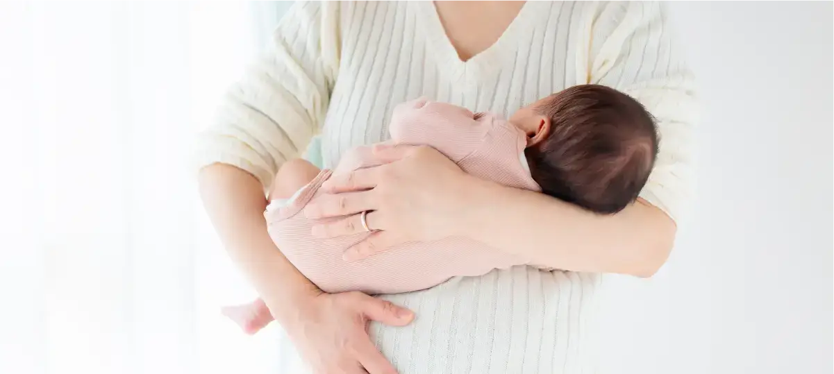 イメージ写真：赤ん坊を抱いている女性